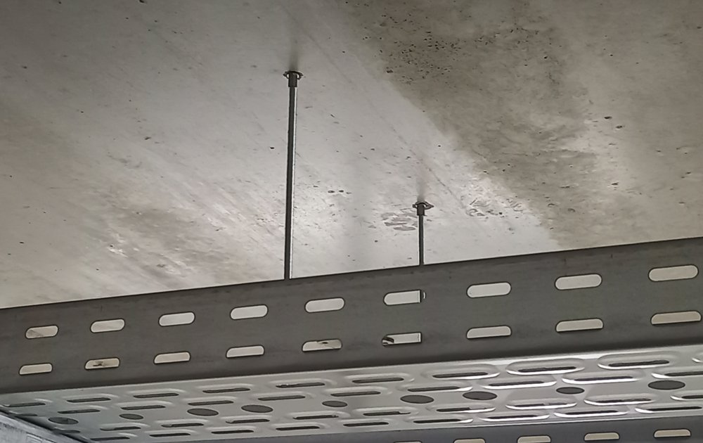 Betonschraube, die zur Befestigung einer Metallkonstruktion an einer Betondecke verwendet wird