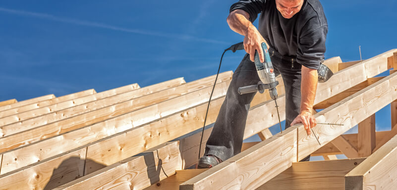 Zimmermann befestigt mit Holzbauschrauben Sparren