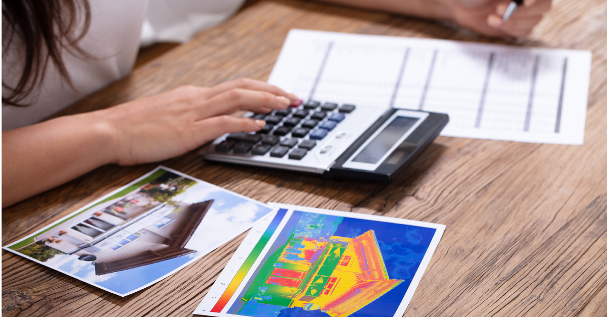 Person benutzt Taschenrechner und analysiert Wärmebilder eines Gebäudes.