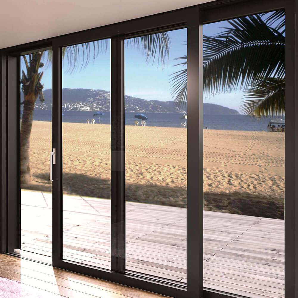 Große bodentiefe Glasfenster mit schwarzen Rahmen, die eine wunderschöne Aussicht auf einen Strand mit Palmen bieten. Die Fenster sind sicher in einem modernen Gebäude montiert, um eine stabile und ästhetische Verbindung zwischen Innen- und Außenbereich zu schaffen.