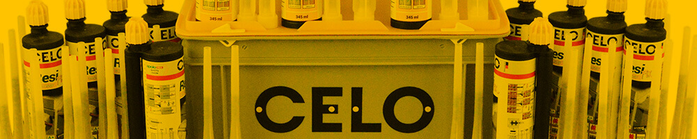 Mehrere Kartuschen mit Injektionsmörtel der Marke CELO, die auf einer Rako-Box stehen. Die Kartuschen sind mit langen Mischrohren ausgestattet und bereit zur Verwendung für chemische Befestigungen. Das Bild ist in einem gelblichen Farbton gehalten.