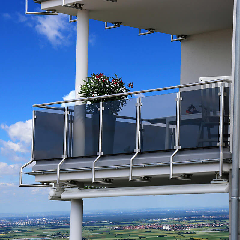 Ein moderner Balkon mit Glasgeländern, der an einem Hochhaus befestigt ist. Die Befestigungselemente des Balkons, einschließlich der Geländer, sind mit chemischen Mörteln verankert, um Stabilität und Sicherheit zu gewährleisten.