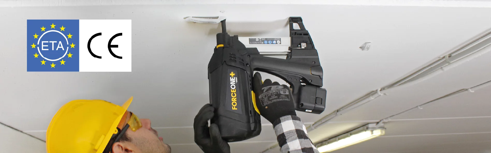 Headerbild Desktop: Handwerker mit Warnweste hält das FORCE ONE Gasnagelgerät in der rechten Hand, neutraler Hintergrund, links oben ist das blaue ETA-Zulassungs-Symbol abgebildet, das aus einem blauen Hintergrund, gelben Sternen und dem Wort "ETA" in weiß besteht