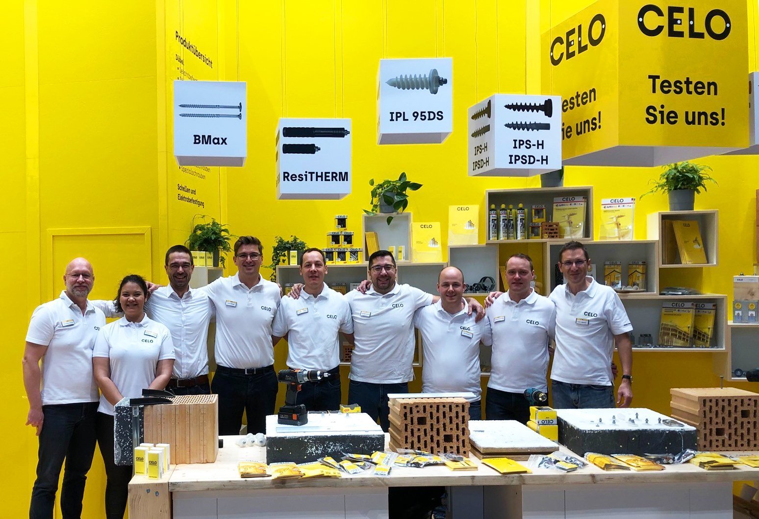 Messeauftritt des CELO-Teams mit gelbem Hintergrund und Produkten