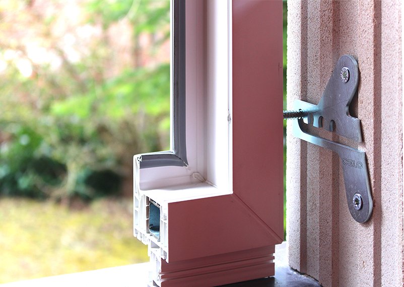 Bild eines Fensterrahmens mit dem ProtectFIX an einem Lochziegel befestigt.