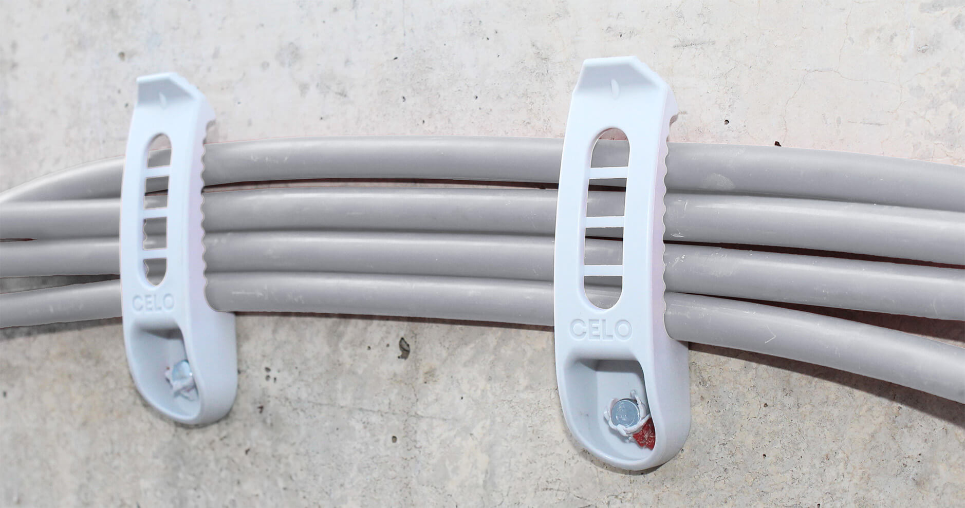 Kabelhalter NCC mit mehreren Kabeln an der Wand befestigt